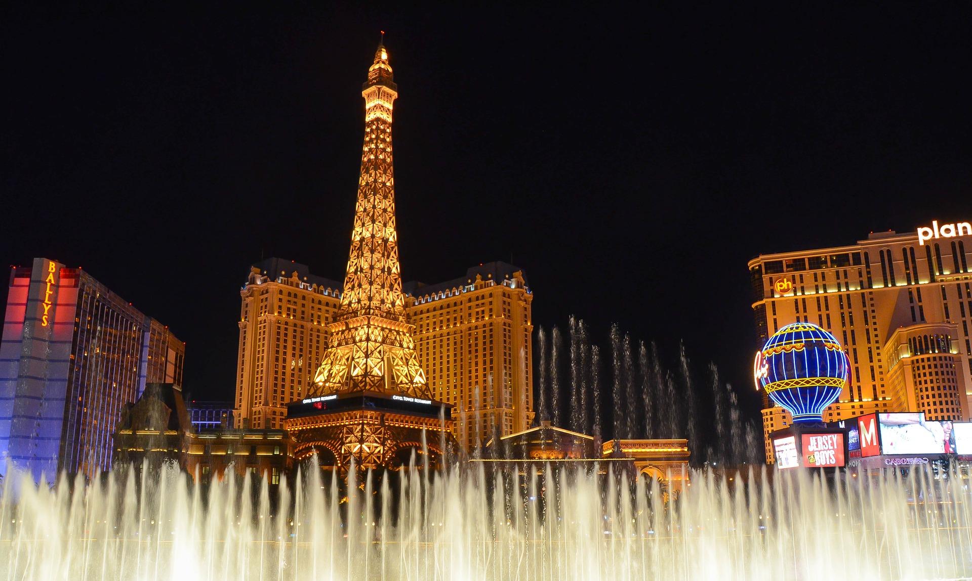 Bellagio’s lakefront dancing fountains in Las Vegas, with the Eiffel Tower Experience in background